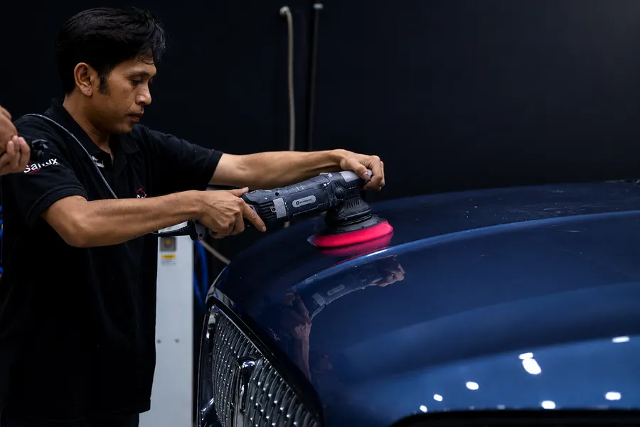 Technician polishing a car